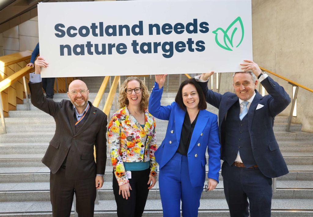 Patrick Harvie (Scottish Greens), Lorna Slater (Scottish Greens), Kate Forbes (Scottish National Party) and Alex Cole-Hamilton (Scottish Liberal Democrats) hold sign which states ‘Scotland needs nature targets’ in the Scottish Parliament.